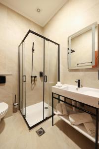 a bathroom with a shower and a sink and a toilet at Hotel Vidović in Banja Luka