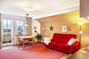 sala de estar con sofá rojo y mesa en Ferienwohnung Zugspitzblick, en Farchant