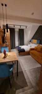 a bedroom with a bed and a table and a couch at Dana Apartmani in Kopaonik