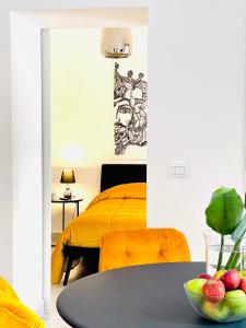 a bedroom with a yellow bed and a table at Sangiuliano Holiday Home in Catania