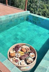 a basket of food on a table next to a pool at Chalé Audaz in Orleans