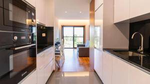 een keuken met witte kasten en zwarte apparaten bij Cute Asprela Apartment by Unique Hosts in Porto