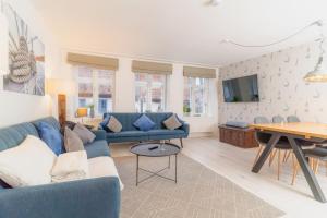a living room with a blue couch and a table at Admiralskoje direkt am Hafen in Flensburg