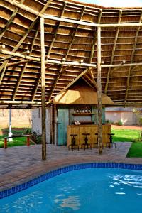 a pavilion with a table and chairs and a pool at Eco-Lodge Gamagara Africa 