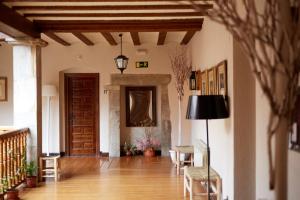 einen Flur mit einer Tür sowie einem Tisch und Stühlen in der Unterkunft Hotel Convento San Roque in Balmaseda