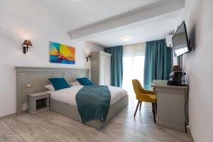 Dormitorio con cama, escritorio y TV en Sky Rooms by Volo Guest House, en Sub Coastă