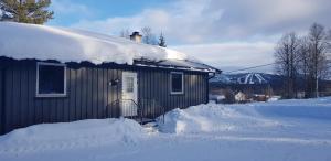 a small house with snow on the roof at Fulufjellet in Ljørdal