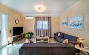 een woonkamer met een bank en een tv bij Katerina Apartment in Afantou