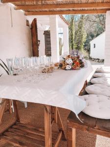 una mesa blanca con copas de vino y flores. en Casa Om, en Dosrius