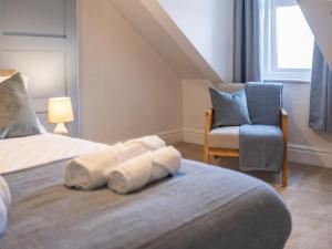 a bedroom with a bed with a blue chair and a window at Cosy Coastal Apartment in Whitley Bay