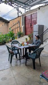 un homme assis à une table dans un patio dans l'établissement Guiltor host, à Chachapoyas