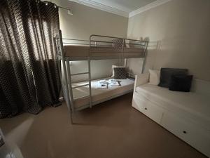 ein kleines Zimmer mit einem Etagenbett und einem Sofa in der Unterkunft Dream House in Albufeira