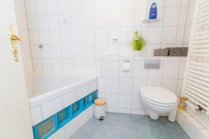 a white bathroom with a toilet and a bath tub at Admiralskoje direkt am Hafen in Flensburg +19 photos