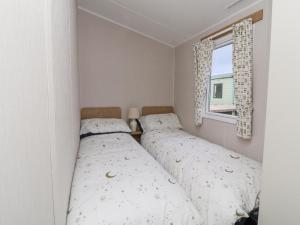 two beds in a small room with a window at The Moon in Morecambe