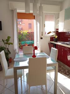 M. BINI B&B في بولونيا: غرفة طعام مع طاولة زجاجية وكراسي بيضاء