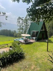 a small house with a green roof and a patio at Chalé Audaz in Orleans