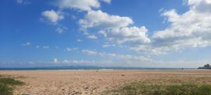 a sandy beach with a cloudy sky and the ocean at One bedroom appartement in Tunis