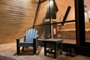 a blue chair and a table with a glass of wine at OUTSCAPE l Cabaña Familiar en mejor sector de Cerro Castillo in Villa Cerro Castillo
