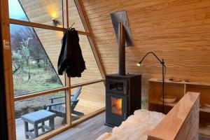 - un salon avec un poêle à bois dans une cabine dans l'établissement OUTSCAPE l Cabaña Familiar en mejor sector de Cerro Castillo, à Villa Cerro Castillo
