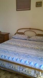 a bed with a blue comforter on top of it at appartamenti del pescatore in Savelletri di Fasano