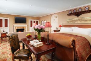 1 dormitorio con 1 cama y 1 mesa con sofá en Summer Lodge Country House Hotel en Evershot