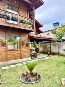 una casa con una maceta en el patio en Millicent Residence - Chalet Milly e Chalet Iris - Itaoca Praia - ES, en Itapemirim