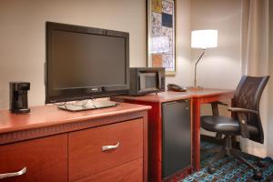 ナンパにあるFairfield Inn & Suites Boise Nampaのデスク、テレビ、ドレッサーが備わる客室です。