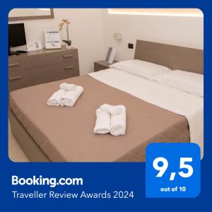 a hotel room with two towels on a bed at Piave77 in Bagheria