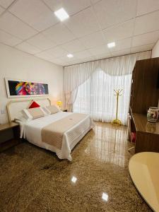 a bedroom with a bed and a large window at Hotel Netto in Cachoeiras de Macacu