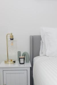 a bedroom with a bed and a nightstand with a clock on it at 'Flinders Lane Flair' Compact City-centre Comforts in Melbourne