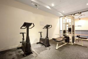 a gym with treadmills and ellipticals in a room at 'Flinders Lane Flair' Compact City-centre Comforts in Melbourne