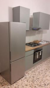 uma cozinha com um frigorífico e um fogão em Casa vacanza Nuvola Rossa KR7 em Crotone