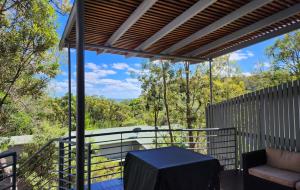 een patio met een schommel en een tafel op een balkon bij Fraser Island - Holiday Heaven in Fraser Island