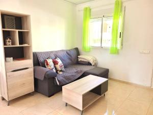 a living room with a couch and a table at Adosado MAR DE CORAL en el Vergel in El Verger
