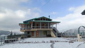a house on top of a mountain in the snow at HighField Villa in Kanatal