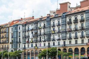 a large white building with a lot of windows at Old Town Core next to Plaza Nueva in Bilbao