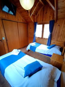 deux lits dans une chambre aux murs en bois dans l'établissement Cabañas del Arroyo, à San Martín de los Andes 11 autres photos