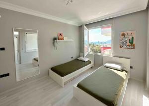 a bedroom with two beds and a large window at Cleopatra Beach l Truly Unique Sea View in Alanya