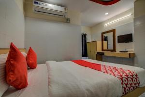 a bedroom with a large bed with red pillows at OYO Mayur's Residency Near Malkpet in Surūrnagar