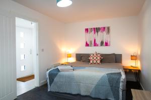 a bedroom with a bed and two lamps and a painting at 1 Bed Heaven Near The Center in Derby