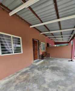 an empty room with two windows and a patio at Umar's Tiny House in Kampong Kemaman