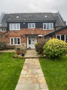 a brick house with a stone walkway in the yard at Cowes - The Barn in Cowes