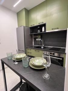 eine Küche mit einem Tisch mit Tellern und Weingläsern in der Unterkunft The luxe Room in Thessaloniki