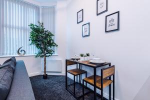 Una sala de estar con una mesa y una planta. en Charming Apartments - Rocky Ln Chambers Flat 4, en Liverpool