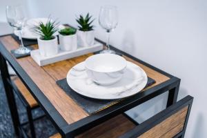 a dining room table with a bowl and plates and wine glasses at Modern abode near city centre/free parking in Liverpool