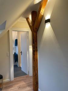 Habitación con vigas de madera y una luz en la pared. en Fewo Haus Peters "De Lütte", en Marschkamp