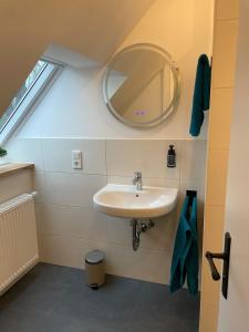 a bathroom with a sink and a mirror at Fewo Haus Peters "De Lütte" in Marschkamp