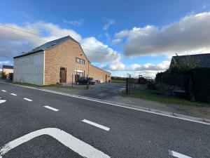 an empty road next to a brick building at Gîte de la vieille grange in Lobbes