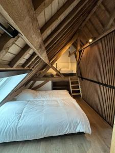 a bedroom with a bed in a loft at Gîte de la vieille grange in Lobbes