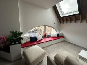 a living room with a red couch and a window at Gîte de la vieille grange in Lobbes